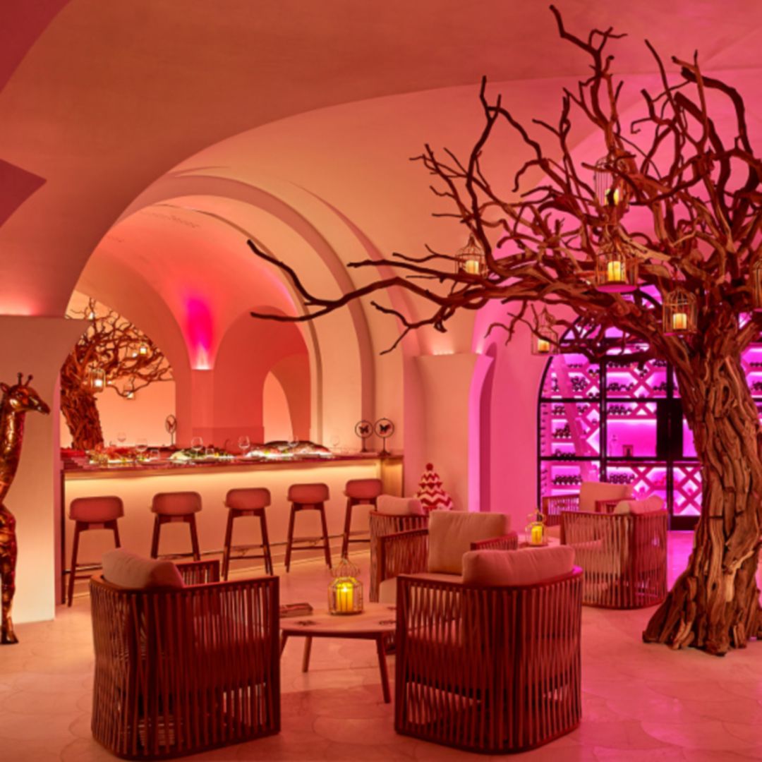 An Indian restaurant with arched ceilings and a tree used as decoration in the middle of the room.